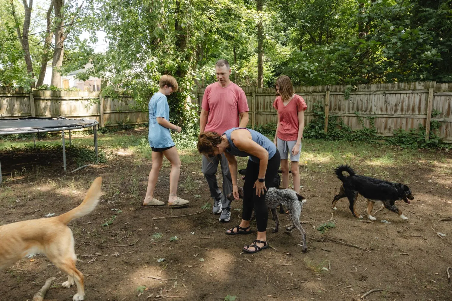The Kergel family in their fenced backyard with four dogs